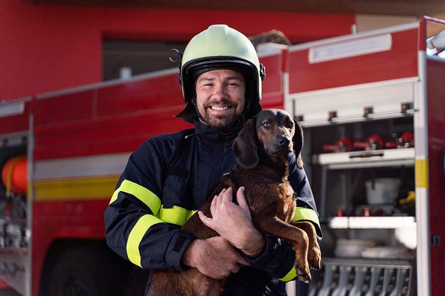 Firefighter with a dog in his arms